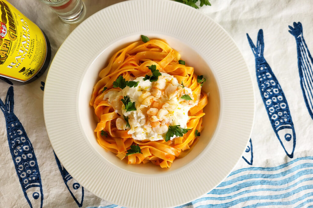 Tagliatelle con bisque e crudo di gamberi, stracciatella e Ratafià al limone